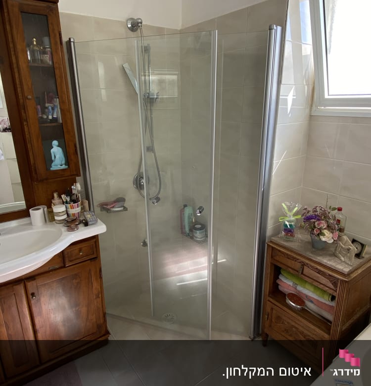 מקלחון זכוכית עם ראש מקלחת ומוצרי טיפוח